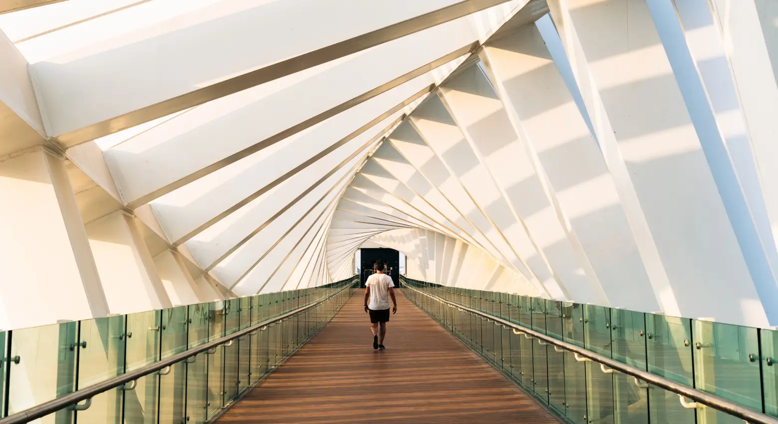 Pessoa andando em ponte entre arquitetura moderna 