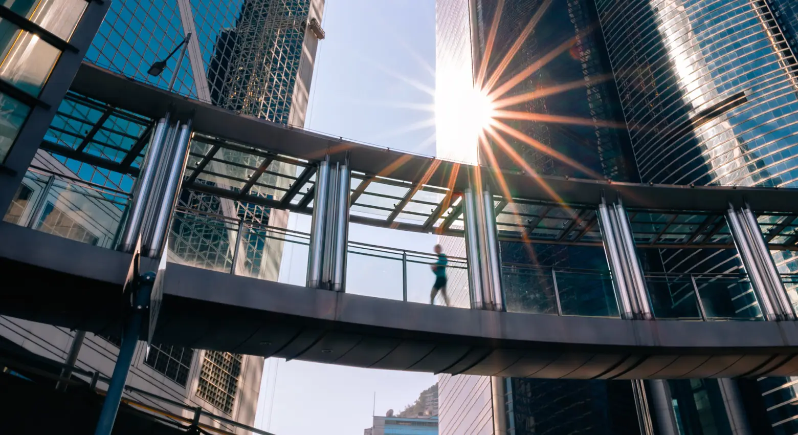Pessoa andando em ponte entre arquitetura moderna 