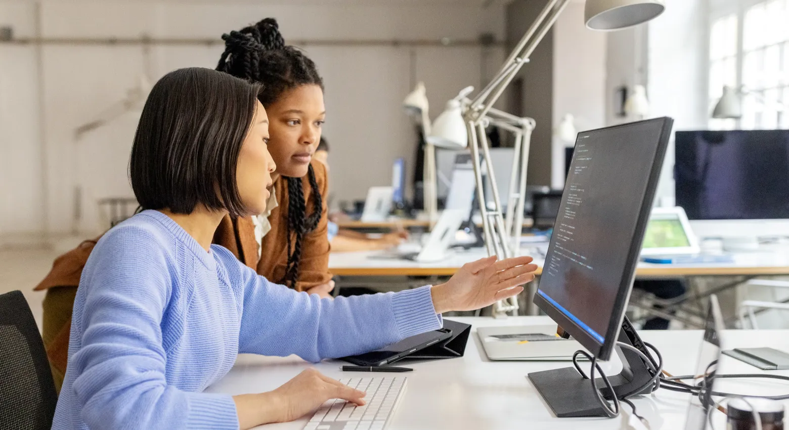 Duas mulheres com computador desktop